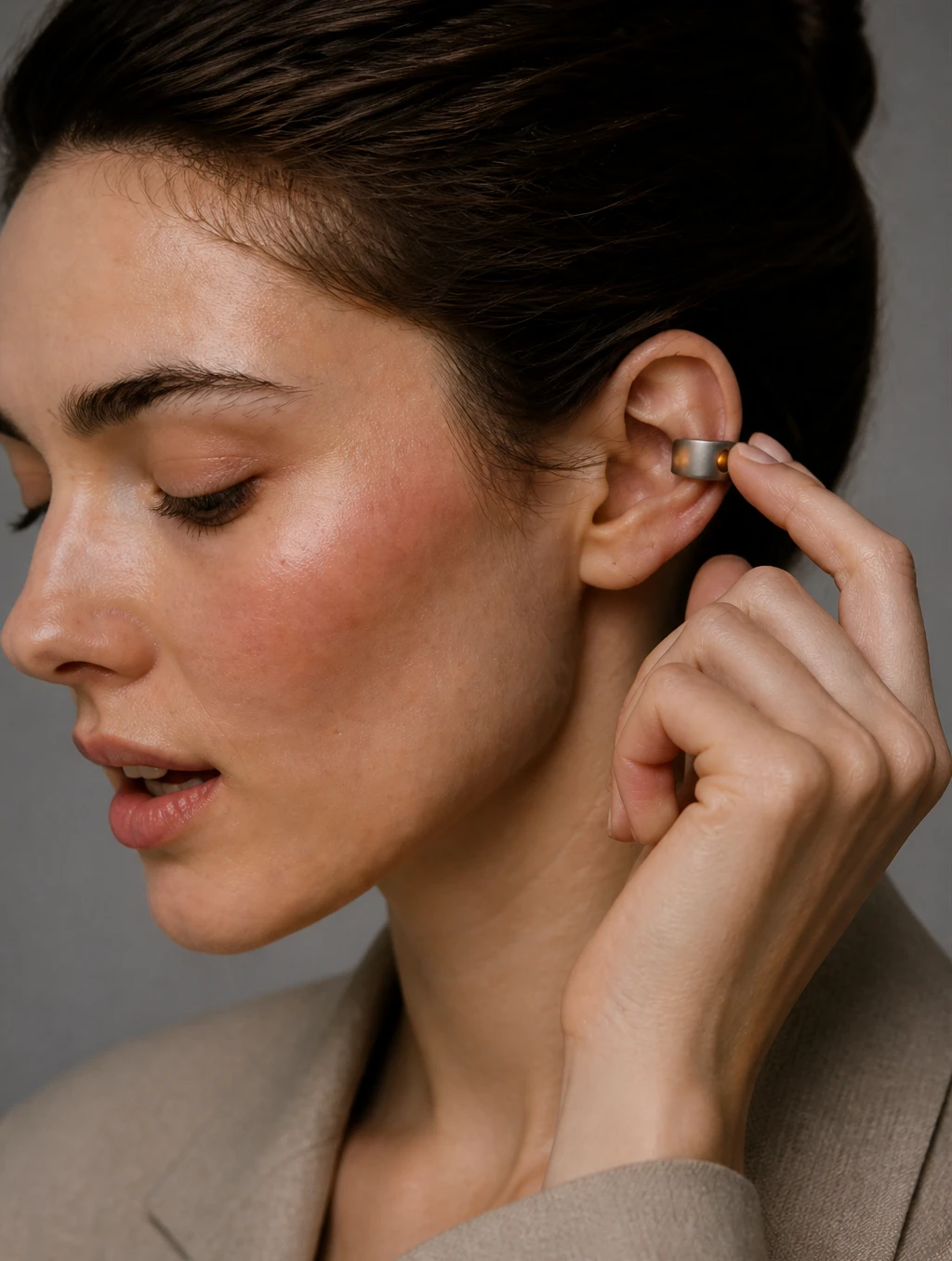 Woman reaching up to the Mote cuff on her ear to start a capture
